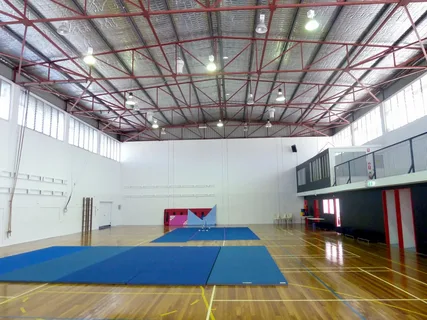 Ceiling fans in a gymnasium helping reduce heat compared to air conditioning.