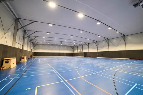 Indoor sports hall environment highlighting need for ceiling fans versus air conditioning.