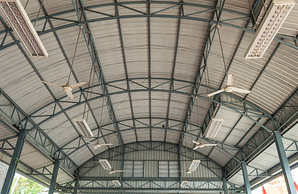 Ceiling fans evenly distributed in an indoor sports facility for heat control.
