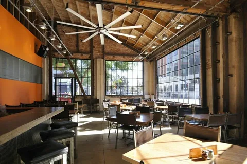 Energy efficient ceiling fan in restaurant reducing cooling costs through better airflow.